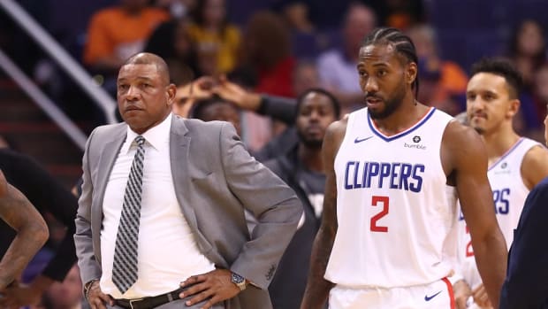 Former Los Angeles Clippers coach Doc Rivers and current forward Kawhi Leonard leave the huddle against the Phoenix Suns at Talking Stick Resort Arena.